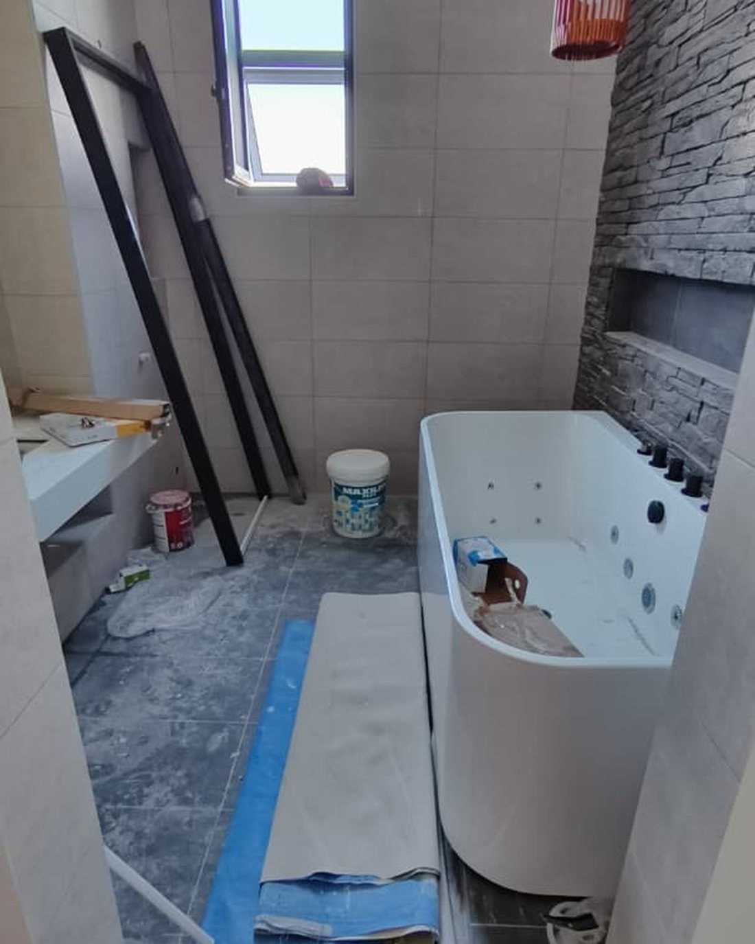 Feature bathtub suite before cleaning with protective sheeting and dust